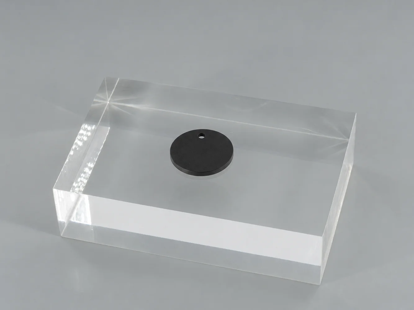 Black polycarbonate chip on a clear block (illustrative image)