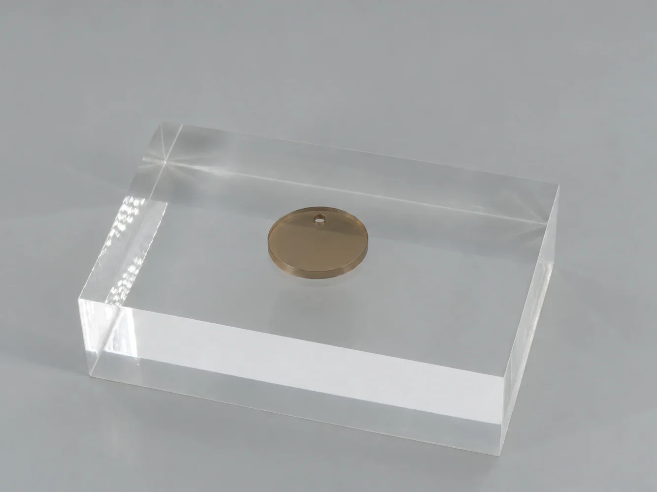 Bronze polycarbonate chip on a clear block (illustrative image)