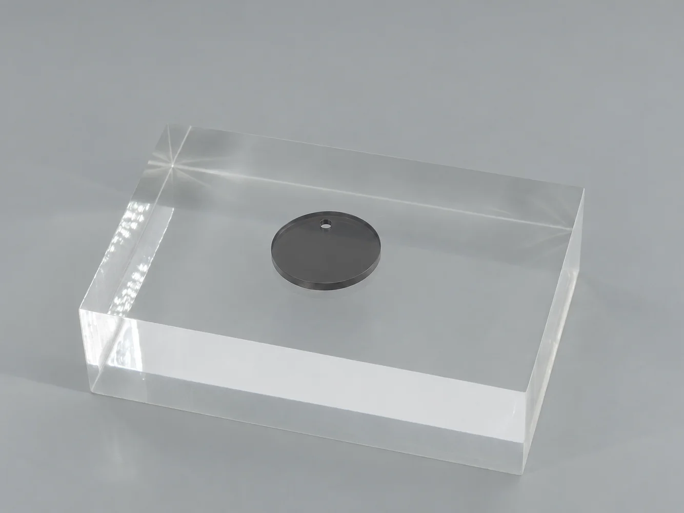 Dark Gray polycarbonate chip on a clear block (illustrative image)