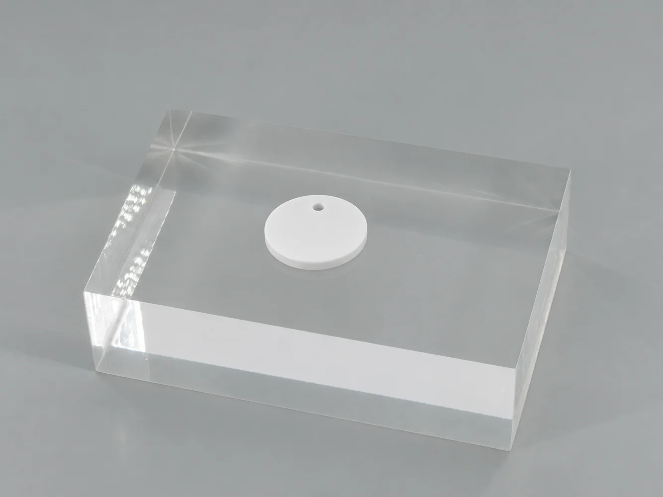White polycarbonate chip on a clear block (illustrative image)